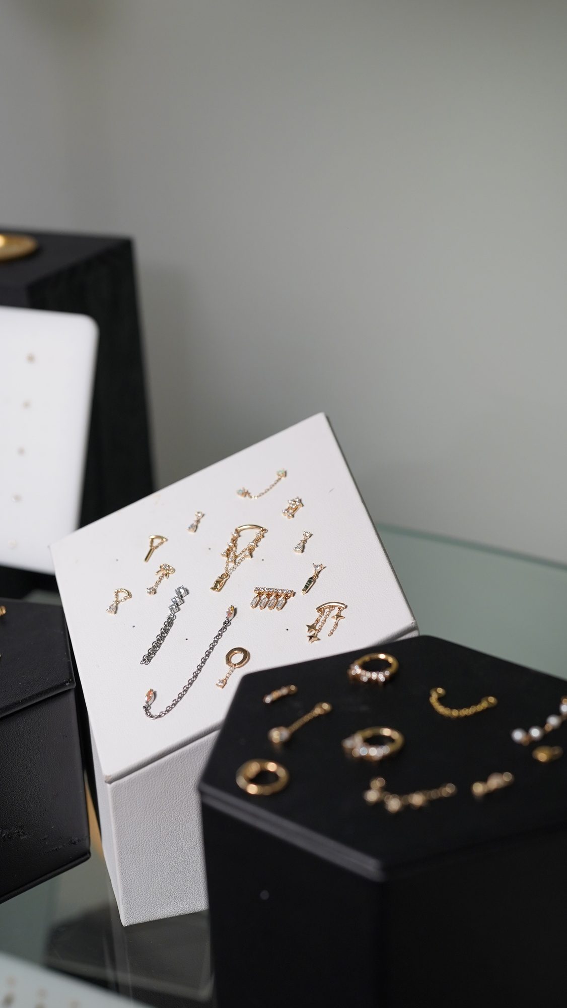 Curated jewelry tray with implant-grade titanium and 14k gold piercing studs and charms at Beach Park Piercing Kailua